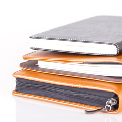 brown and black leather diary books.