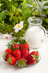 Plate with fresh strawberries with milk