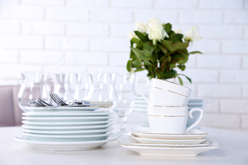 Clean plates, glasses and cutlery on white table