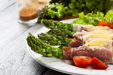 Baked green asparagus with prosciutto and cheese