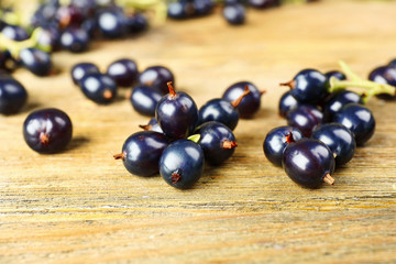 Ripe black currants on wooden background