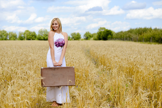 Perfect picture of long haired blond lady in golden field. 