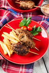 Barbecued kofta with fries on a plate