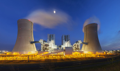 A modern brown coal power station with night blue evening sky. Panoramic wide angle shot.