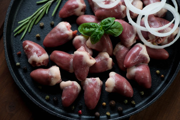 Close-up of raw chicken hearts with seasonings, above view