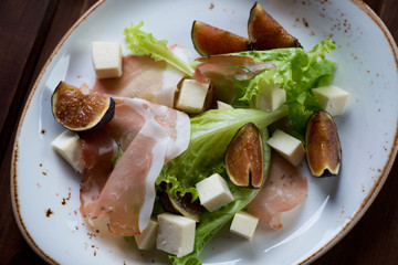 Top view of fresh fig fruits, cheese and ham salad, close-up
