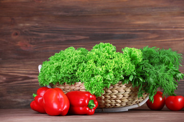 Fresh vegetables and greens on wooden background