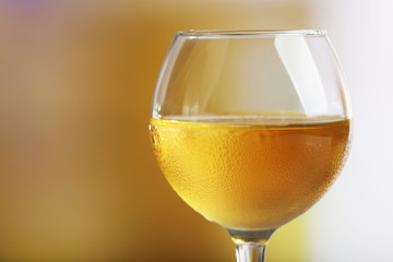 Glass of wine on light blurred background