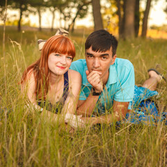 couple lying next to each other in a meadow, outdoors