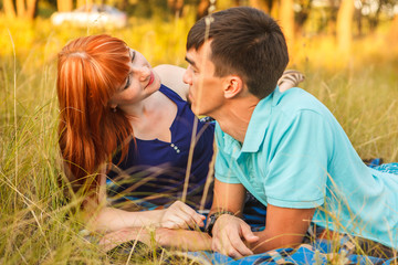 couple lying next to each other in a meadow, outdoors