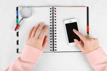 Hands working in the office with notebook and phone, on white background