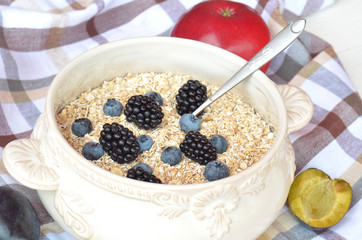 Bowl of fine oat flakes with fresh fruit