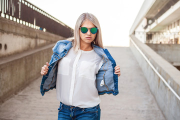 beautiful girl in a denim suit posing in city outdoors