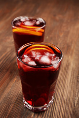 Glasses of cherry juice on wooden background