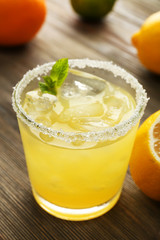 Glass of lemon juice on wooden table, closeup