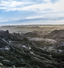 coast with Stones of volcanic flow and ocean