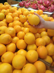 Female Hand pick up Orange in market