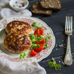 pork cutlet and vegetable salad on a dark wooden background