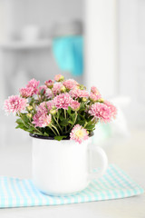 Beautiful flowers in vase on table, on light background