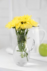 Beautiful flowers in decorative vase on light background