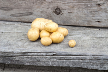 Small group of fresh natural potatoes on wooden texture
