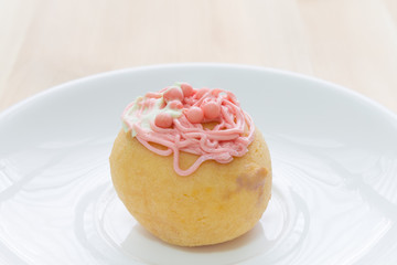 Red Choux or Profiterole or Eclair on Wood Table