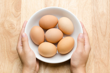 Egg in the bowl hold by hand, food ingredient