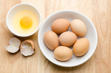 Fresh egg and yolk in the bowl on wooden background,ready to cooking,food ingredient
