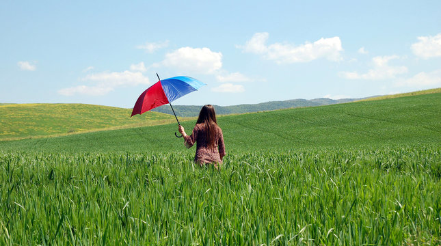 Donna con ombrello su prato verde