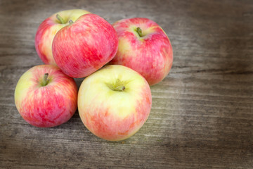 Small group of fresh natural apples on wooden texture