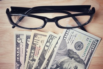 Many dollars banknotes with glasses.