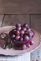Fresh red grapes in a purple bowl