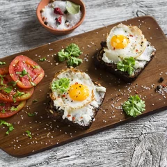 Crédence de cuisine en verre imprimé Oeufs sur le plat toast with feta cheese and fried quail egg, fresh tomatoes on a light wooden surface - a healthy Breakfast or snack
