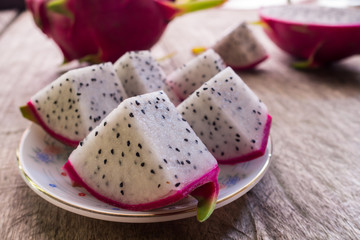 Dragon Fruit and some slice on old Wooden Table