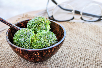fresh broccoli in wooden bowl on pattern bamboo for background