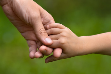 adult holding a child's hand