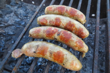 Pork - beef sausages on grill in the summer garden