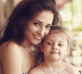 Happy smiling mother cuddling her cute daughter. Closeup toned p