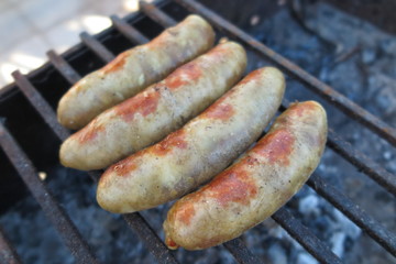 Pork - beef sausages on grill in the summer garden
