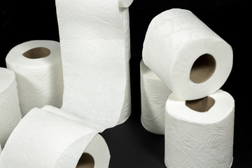 Rolls of toilet paper with embossed decorative patterns, on black