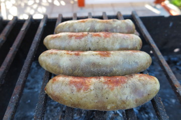 Pork - beef sausages on grill in the summer garden