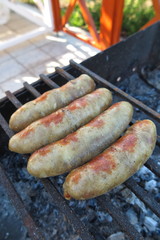 Pork - beef sausages on grill in the summer garden