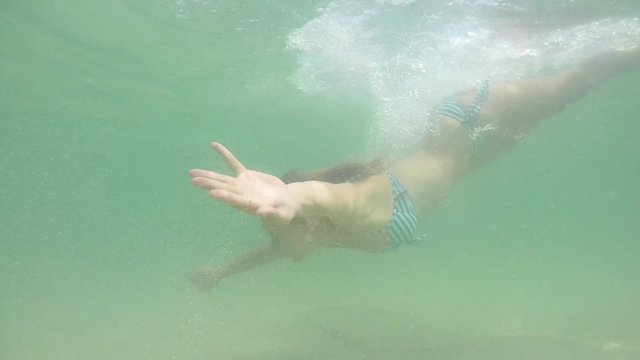 Young Attractive Woman Swimming Underwater. Slow motion.