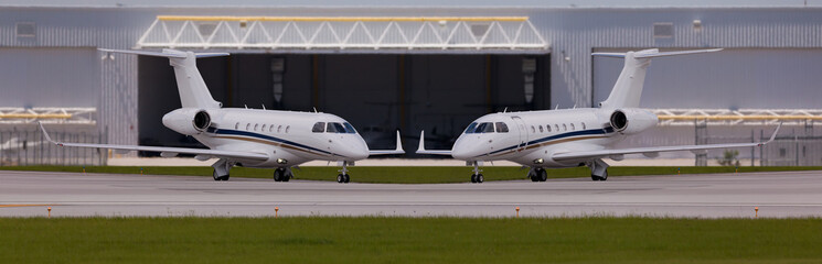 Two private planes in front of a hangar - obrazy, fototapety, plakaty