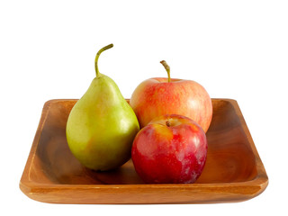 Apple, pear and plum on a wooden plate