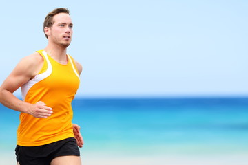 Fototapeta premium Handsome fit Running young man jogging on shore. He is in sports clothing. Determined male jogger is exercising at beach.