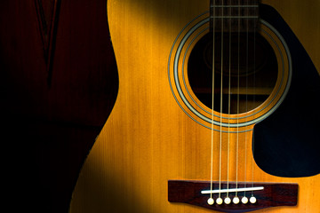 Obraz premium Detail of acoustic guitar in dark room with retro filter effect
