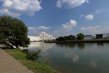 Fototapeta na wymiar Residential white apartment house on the banks of the narrow river