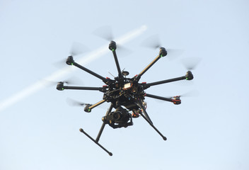 A drone with a camera flying high above a residential area - obrazy, fototapety, plakaty
