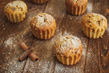 Light muffins with sesame on dark wooden background